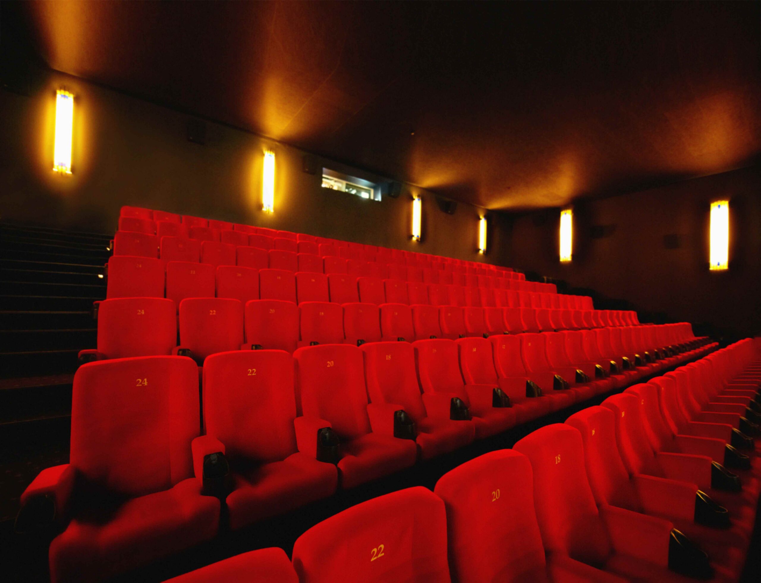 Empty red seats in a movie theater  scaled