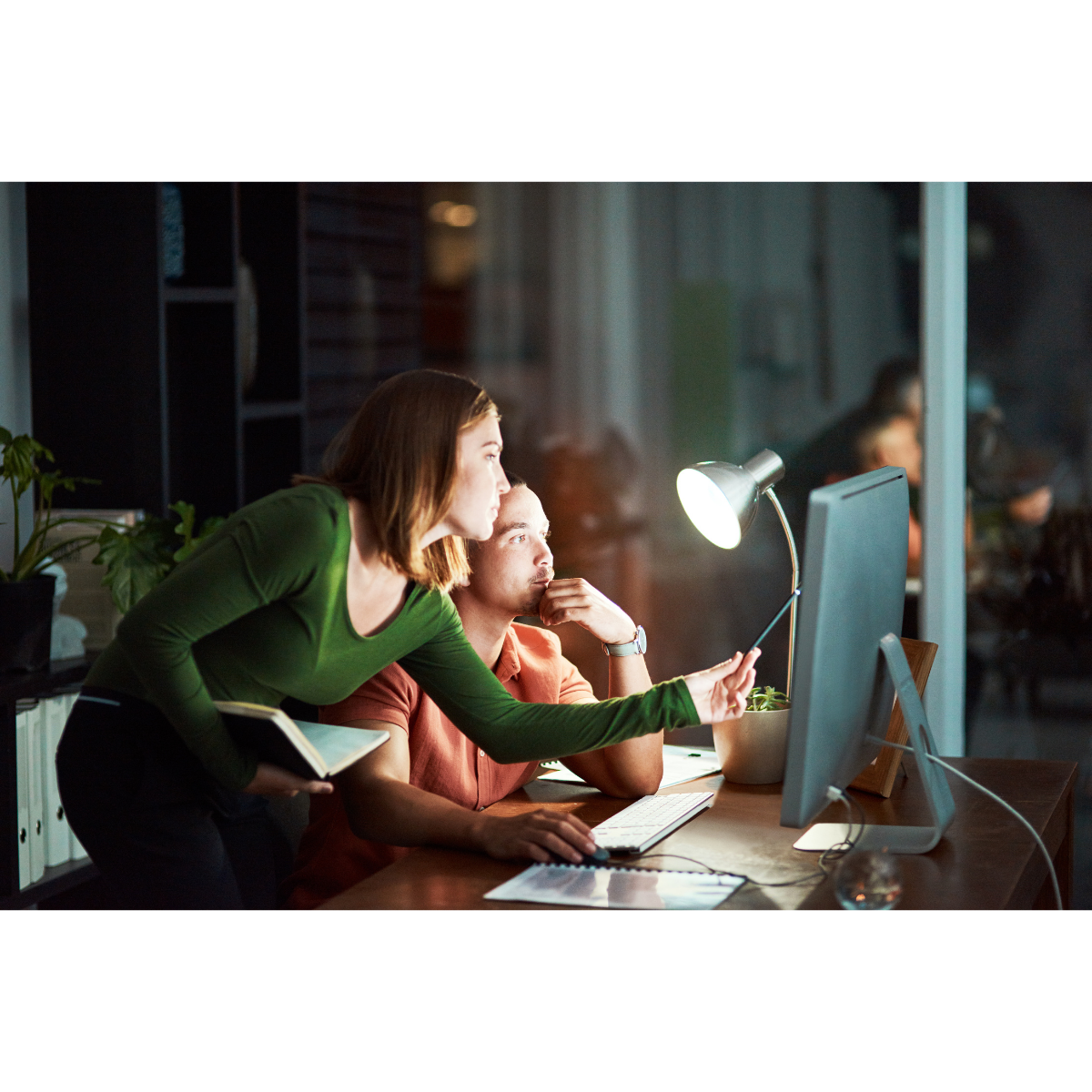 Two people working together on a computer to fix a technical issue