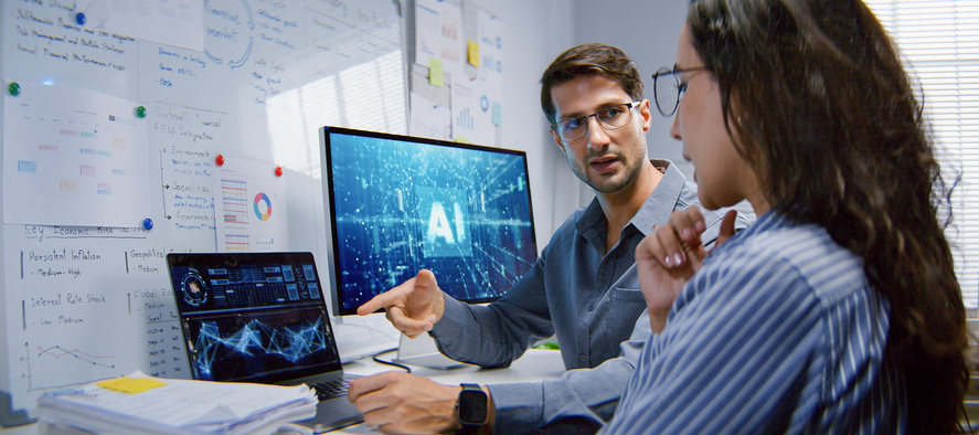 Two professionals discussing AI-based test automation strategies with AI dashboard on screen