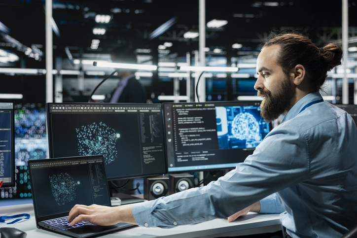 Engineer working on AI-based test automation with multiple screens displaying intelligent QA automation systems