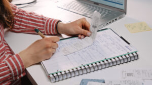 Person writing test automation plans in a notebook for structured QA automation services