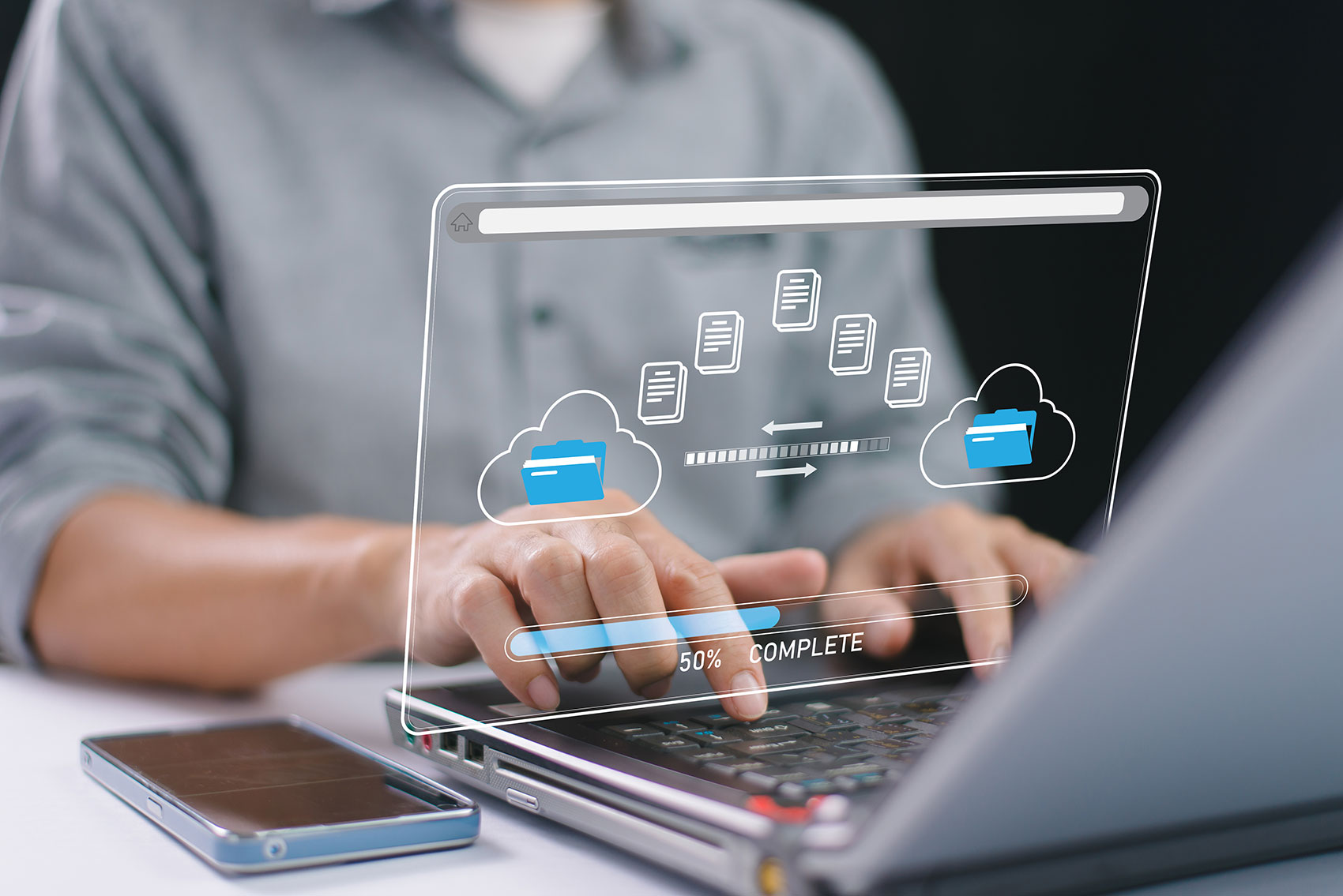 Hands typing on a laptop with a glowing cloud file transfer interface overlay