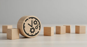 Wooden block with a clock and gear icon surrounded by smaller blocks on a neutral surface