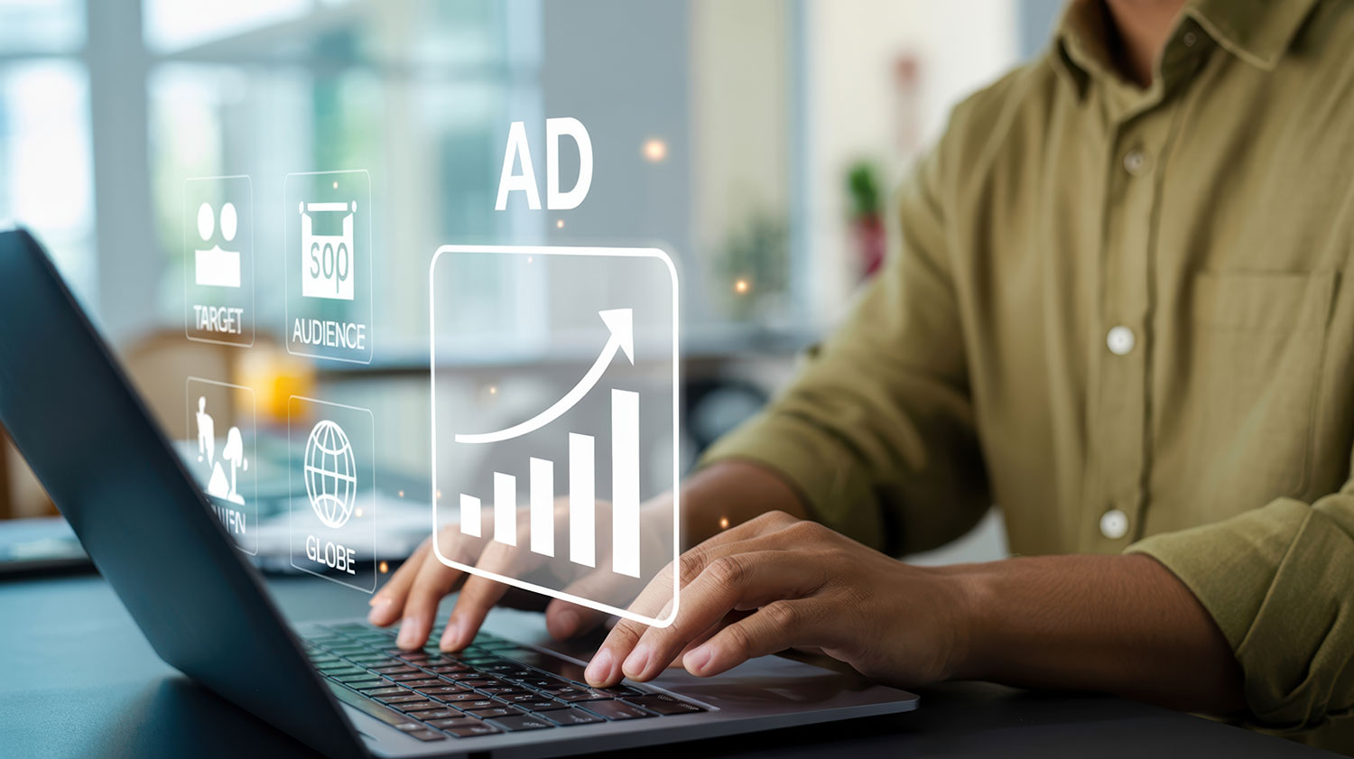Person using a laptop with a glowing AD growth chart graphic overlay