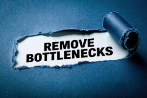 Torn paper revealing the text "Remove Bottlenecks" on a blue background