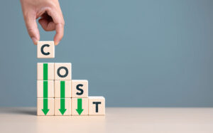 Wooden blocks spelling cost with downward green arrows on a blue background