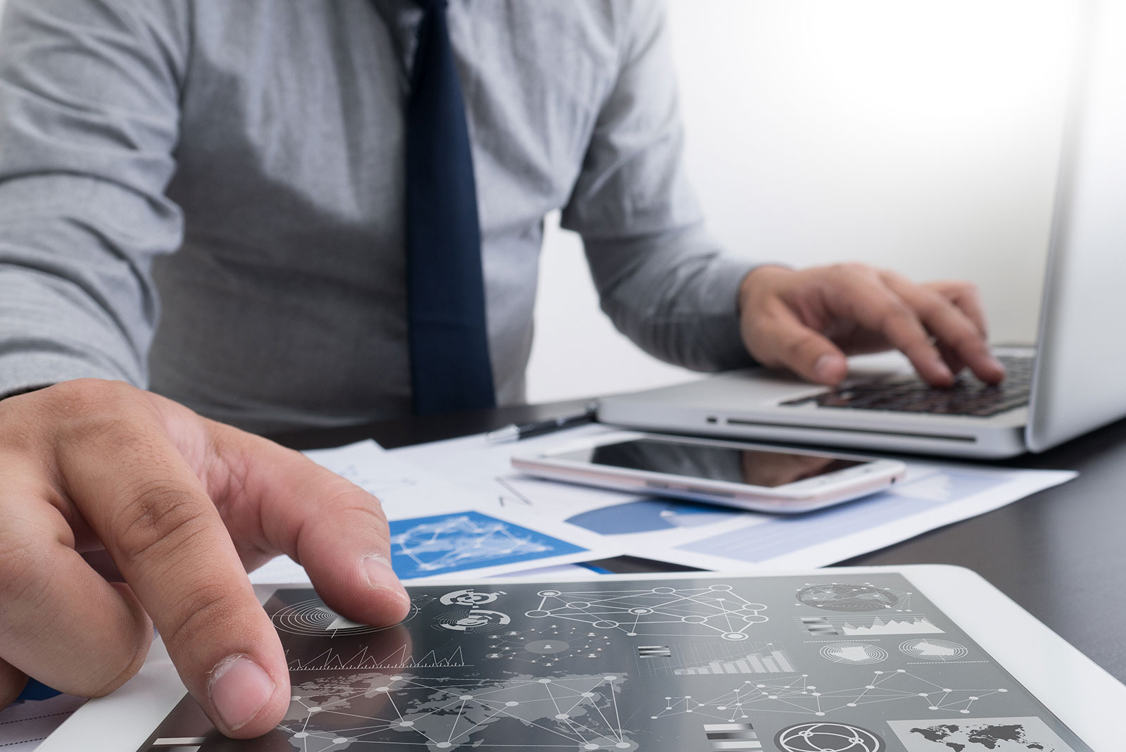Professional reviewing CI Plus common interface testing reports on tablet and laptop