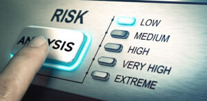 Finger pressing a risk analysis button with a scale from low to extreme levels