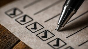 Pen checking boxes on a checklist representing thorough mobile and web application testing process