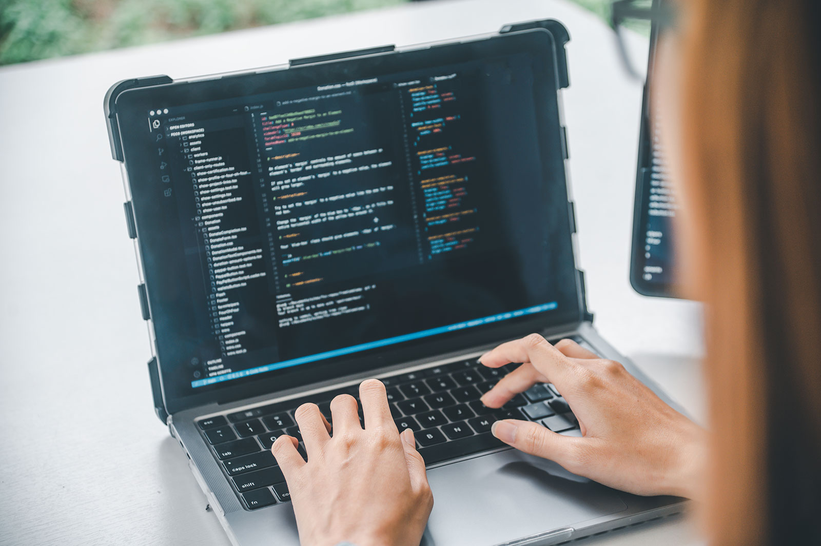 QA engineer performing AI-powered software testing and digital assurance coding on laptop
