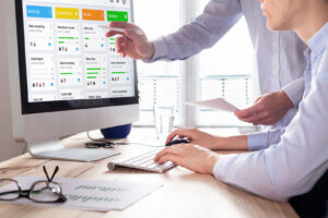Team reviewing software QA metrics and digital assurance testing reports on desktop dashboard