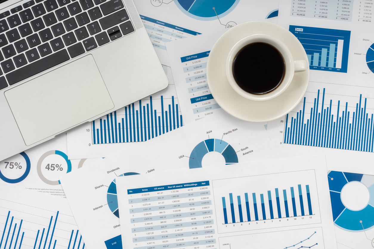 Laptop and coffee cup on desk with web app testing reports and analytics charts