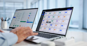 Professional managing digital assurance testing workflows and software QA dashboards on laptops