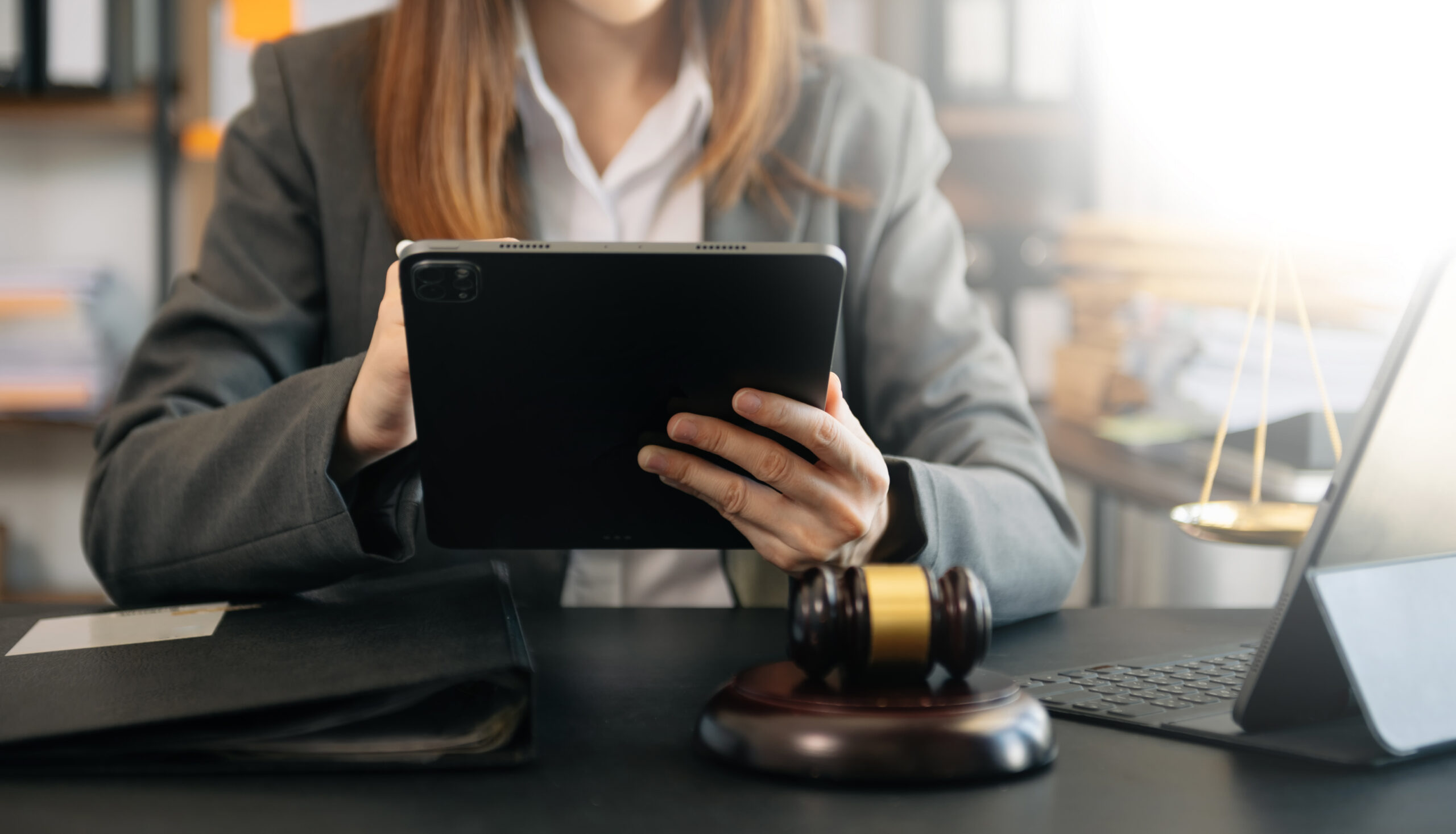 Legal professional reviewing documents on tablet