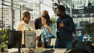 Diverse team collaborating around a computer in a modern office workspace