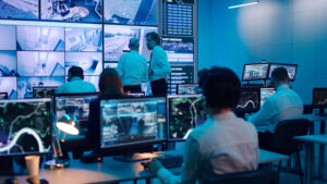 Team monitoring live feeds and data across multiple screens in a control room