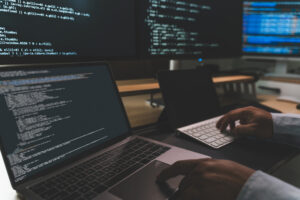 Developer writing automation test scripts on laptop for selenium-based QA automation services