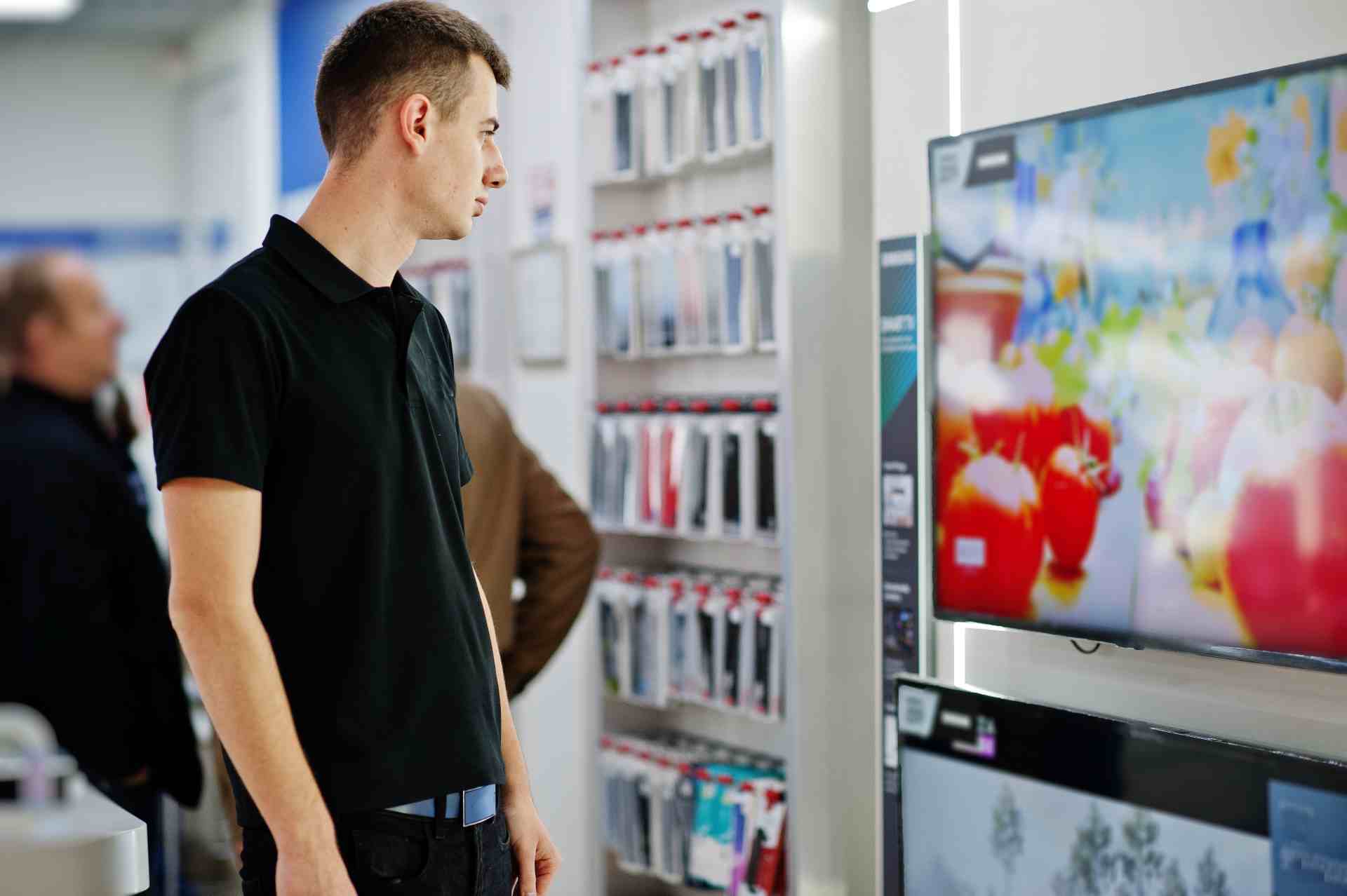 Young man in store looking at television 2026 03 18 13 50 43 utc