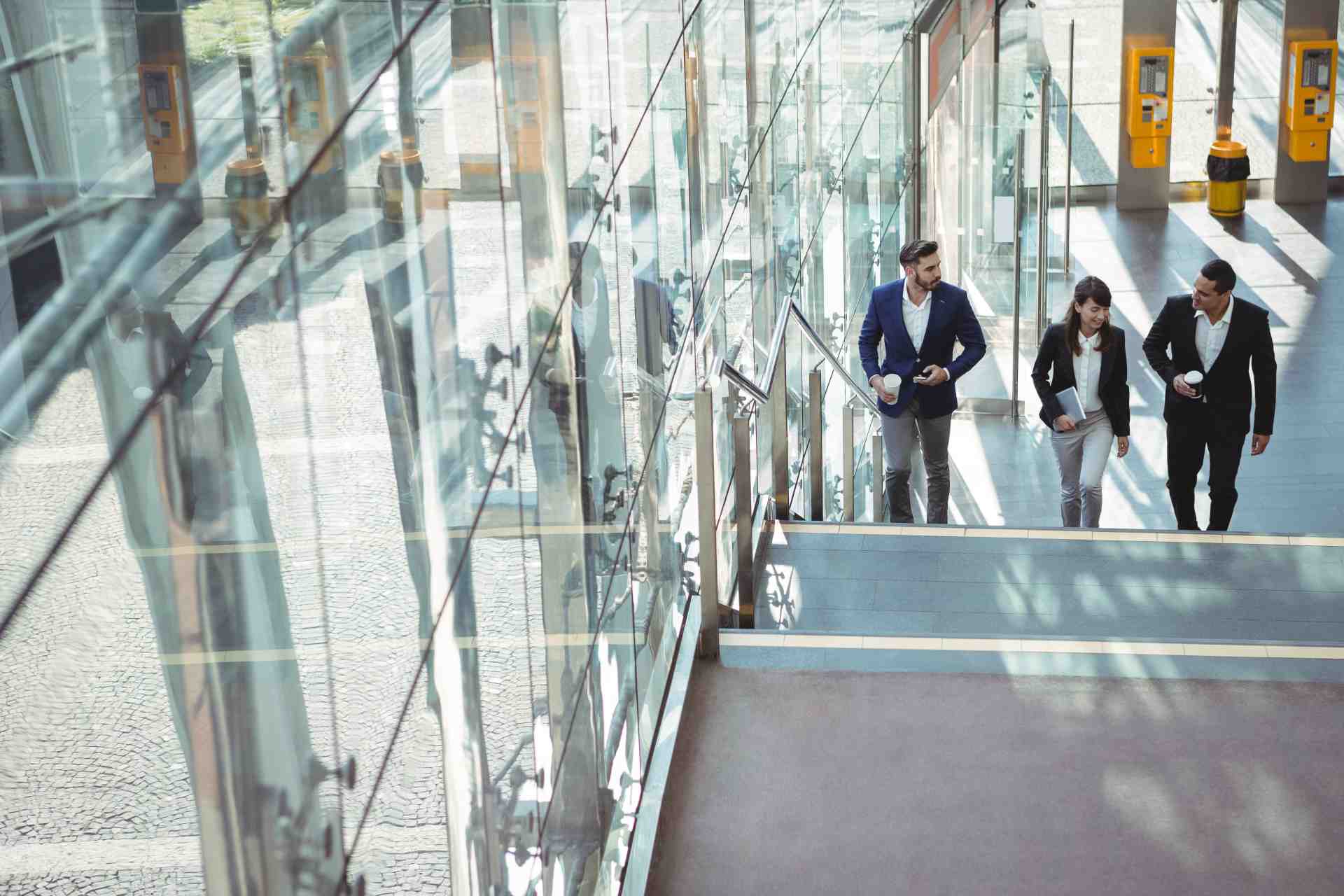Three professionals walking on staircase in modern 2026 01 09 09 14 17 utc