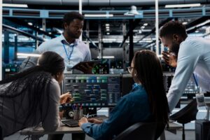 Team analyzing data on multiple monitors in a modern tech operations center