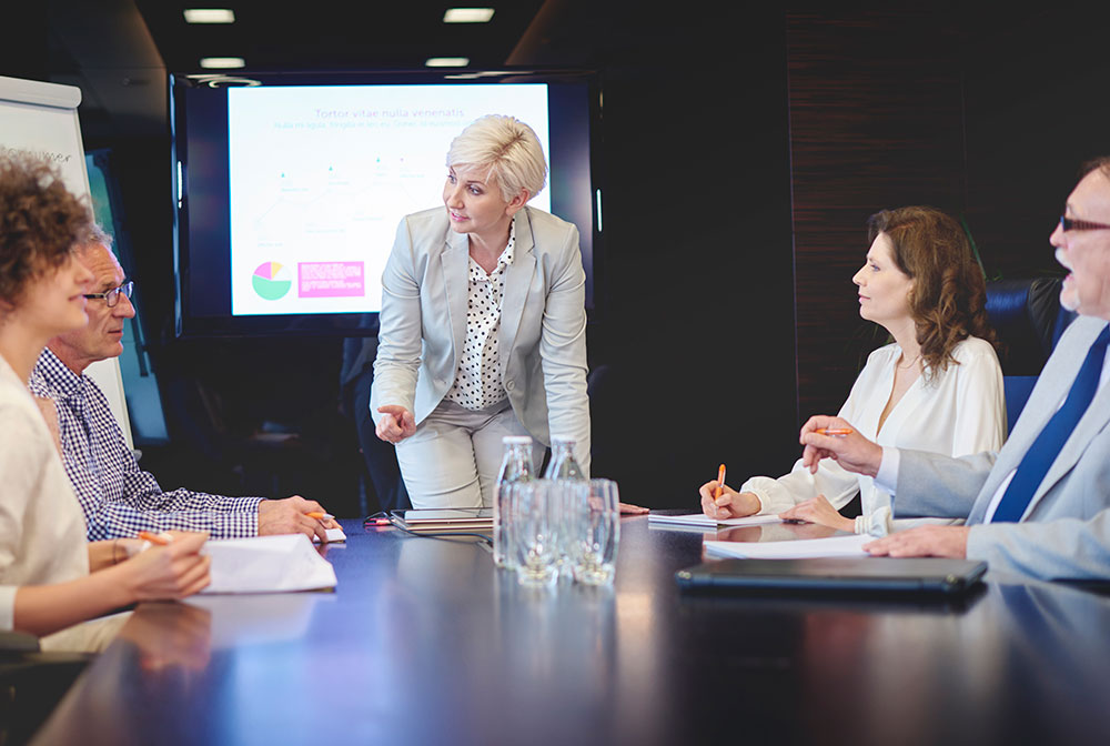 Business leader leading a strategy discussion with data charts in a boardroom