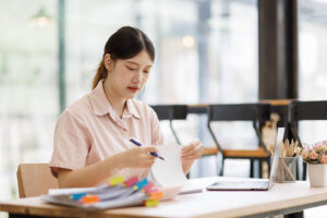 Employee sorting through tagged paperwork at an office desk