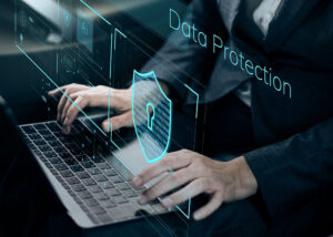 Person typing on laptop with digital data protection and security shield overlay
