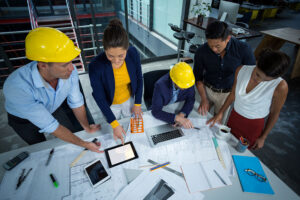 Construction team reviewing building blueprints and project plans