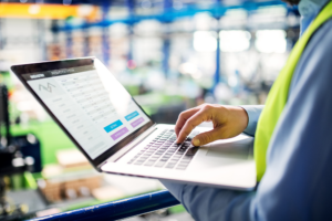 Industrial professional managing AI workflow automation and agent orchestration on laptop
