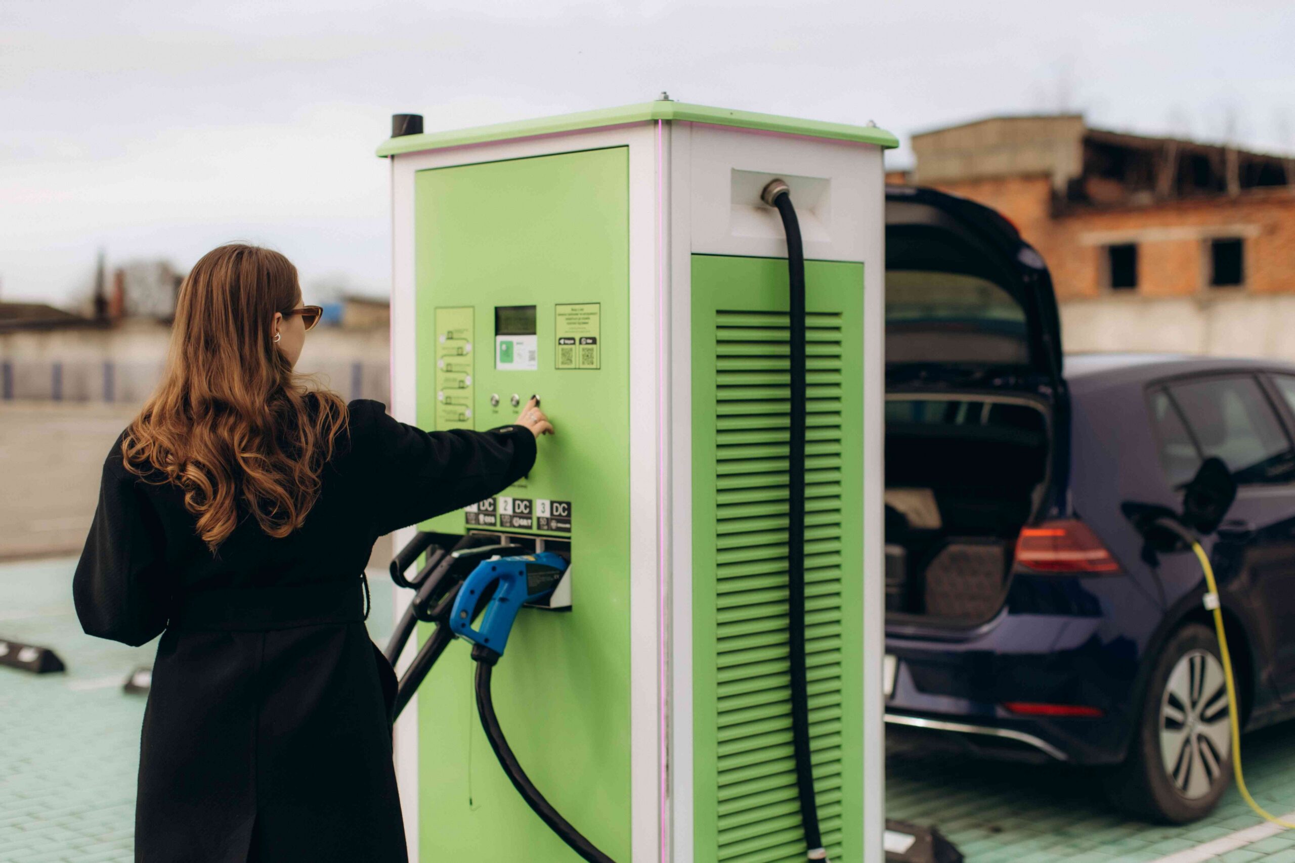 Woman charging electric car at public station 2026 03 26 23 29 29 utc scaled
