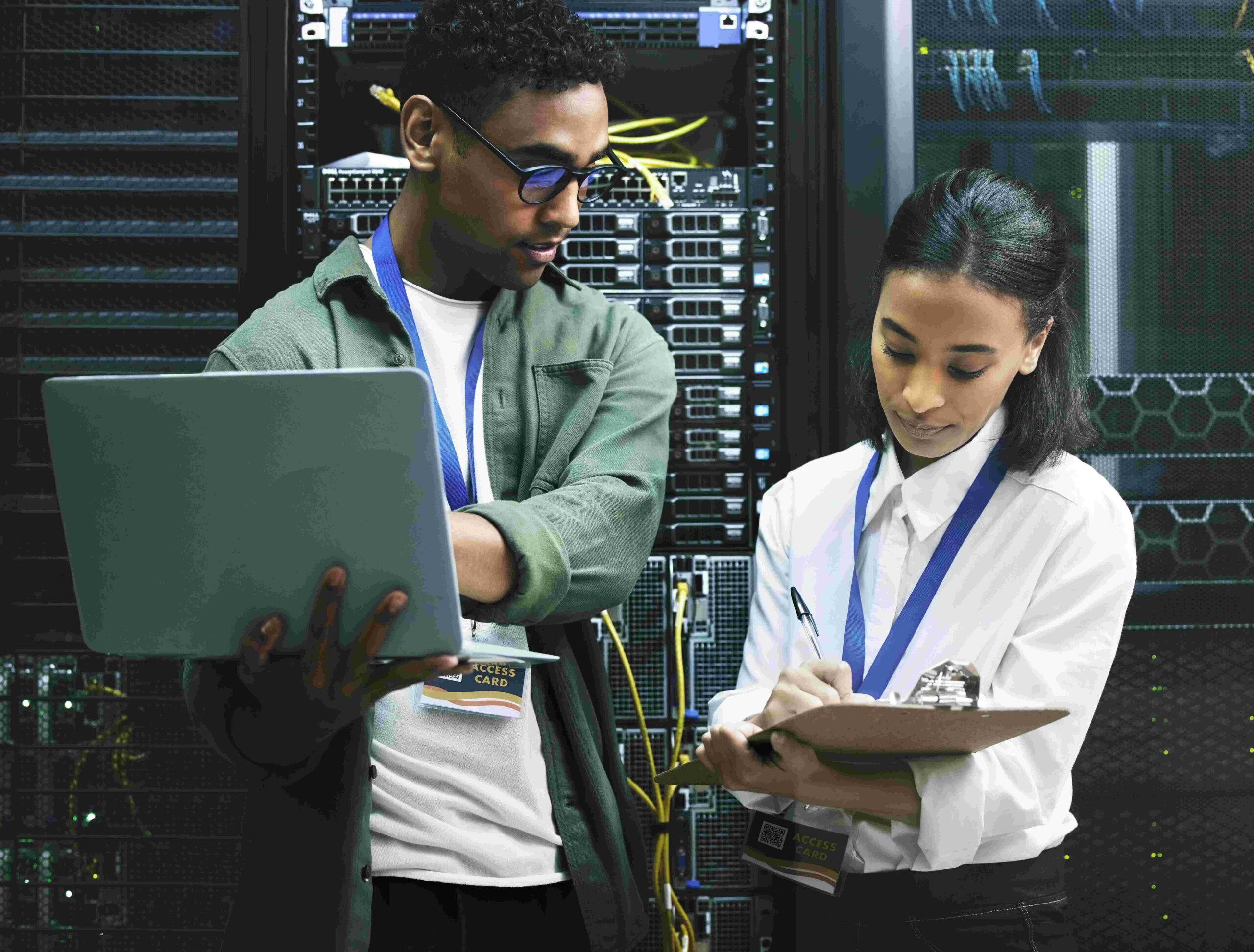 IT staff checking laptop data near server racks