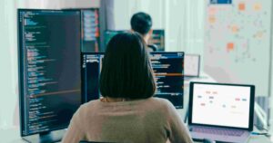 Developers coding on multiple screens