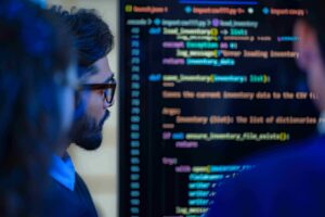 People reviewing data code on screen