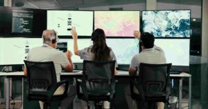 Team monitoring satellite imagery across control room screens